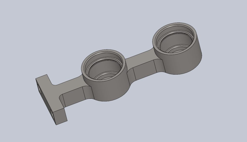 3D CAD model of a double-boss mounting bracket with two circular holes connected by a narrow neck and a flange on one end