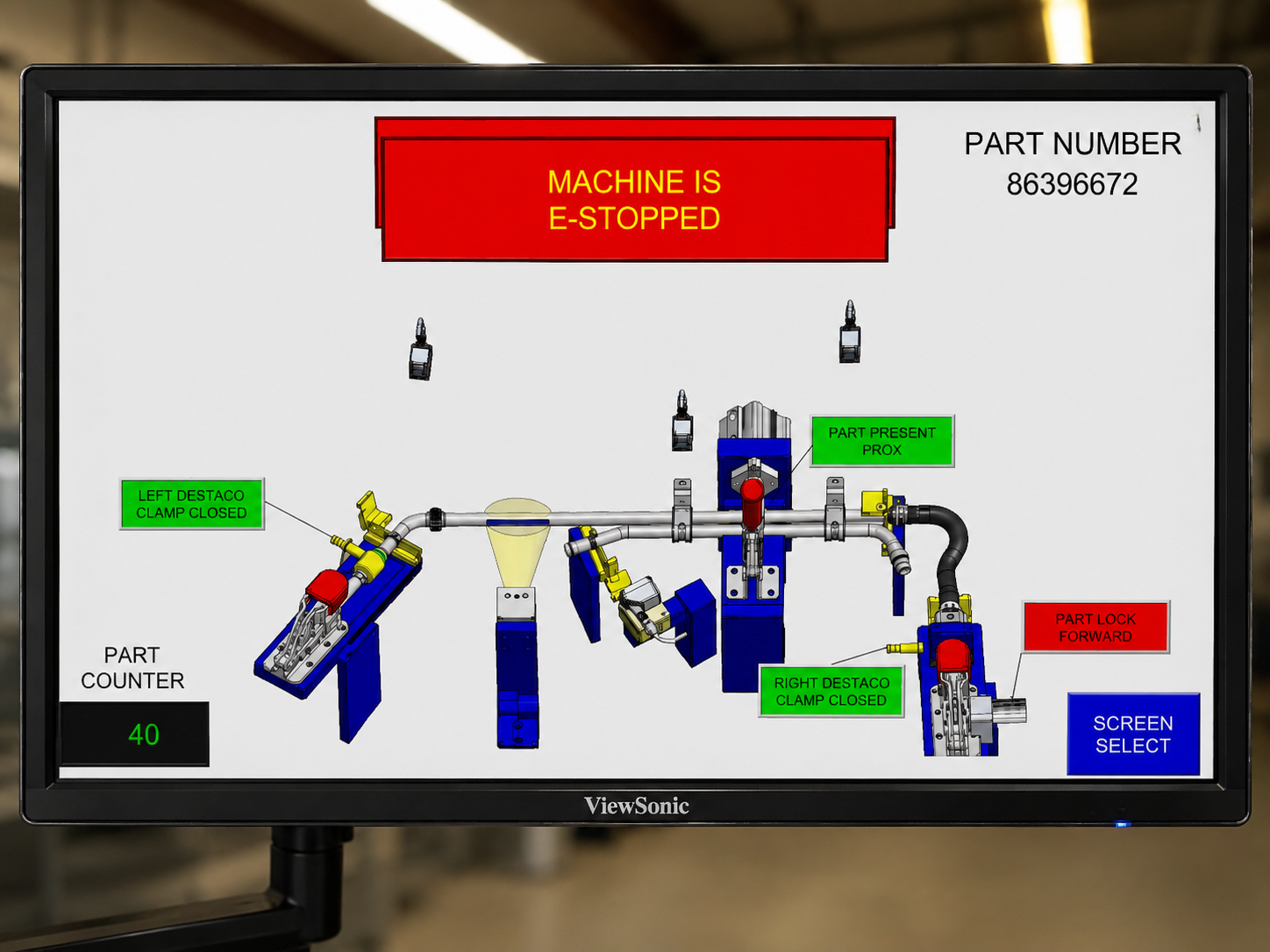 Monitor showing an industrial machine diagram with a red 'MACHINE IS E-STOPPED' banner and part counter '40' at lower left.